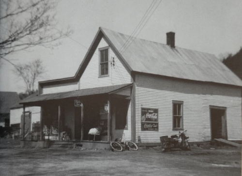 The closed Village Store in winter, with a banner reading It Takes a Village Store